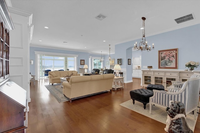 living room featuring ornamental molding, dark hardwood / wood-style floors, and a chandelier