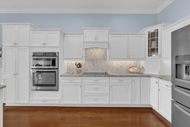 kitchen featuring stainless steel appliances, white cabinetry, light stone countertops, tasteful backsplash, and glass insert cabinets