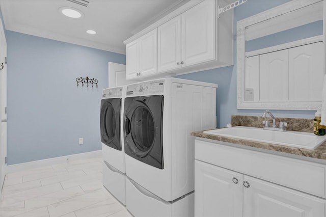 laundry area featuring cabinets, ornamental molding, washer and clothes dryer, and sink