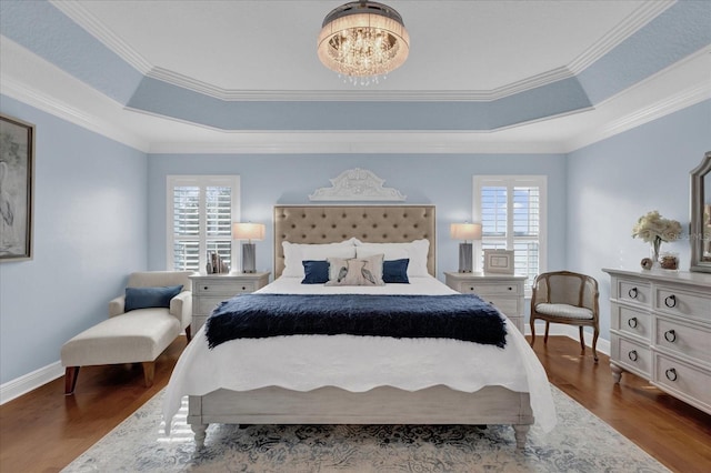 bedroom featuring a raised ceiling, dark hardwood / wood-style flooring, and multiple windows