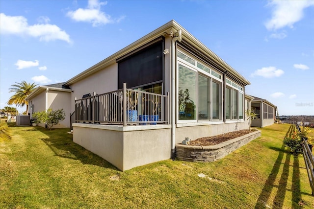 view of side of property featuring central AC and a lawn