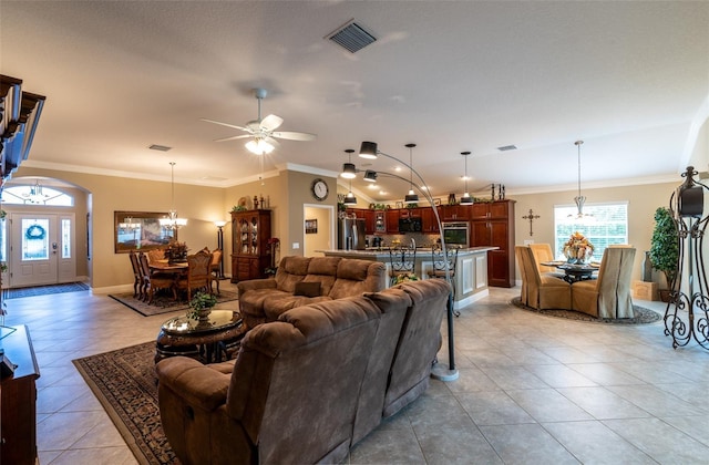 tiled living room with crown molding and ceiling fan with notable chandelier