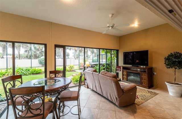 living room with ceiling fan, a textured ceiling, and light tile patterned floors