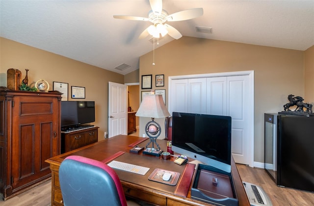 home office featuring vaulted ceiling, light hardwood / wood-style floors, and ceiling fan