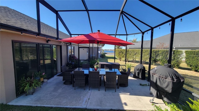 view of patio with area for grilling and a lanai