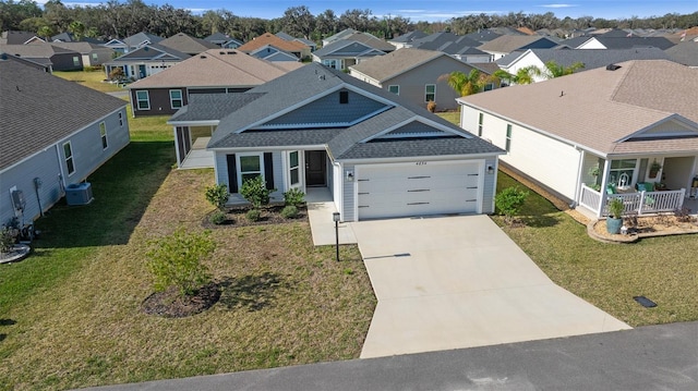 view of front facade with a garage, cooling unit, covered porch, and a front lawn