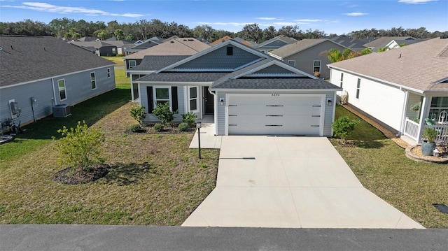 view of front of property with a garage, a front yard, and central air condition unit