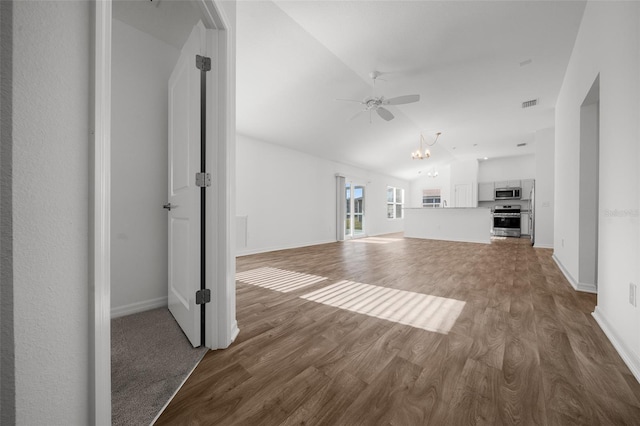 unfurnished living room featuring hardwood / wood-style floors, ceiling fan with notable chandelier, and vaulted ceiling