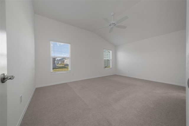 carpeted spare room featuring vaulted ceiling and ceiling fan