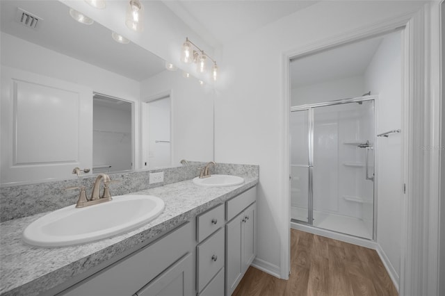 bathroom with vanity, hardwood / wood-style floors, and a shower with shower door