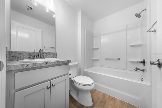 full bathroom featuring hardwood / wood-style flooring, shower / bathtub combination, vanity, and toilet