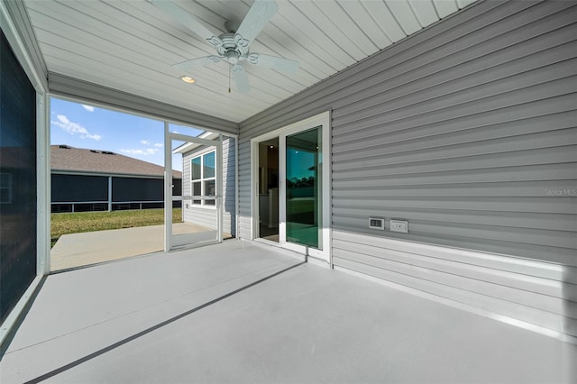 unfurnished sunroom with ceiling fan