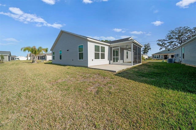 back of property with cooling unit, a sunroom, a yard, and a patio