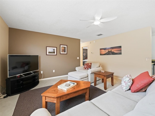 living room with ceiling fan and a textured ceiling