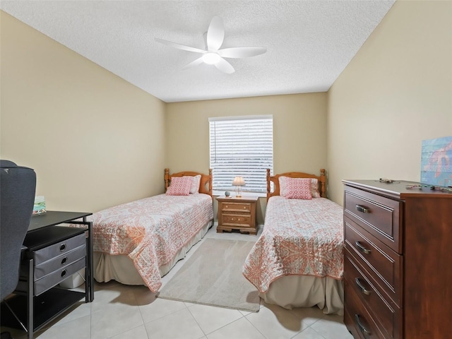 bedroom featuring ceiling fan, a textured ceiling, and light tile patterned floors