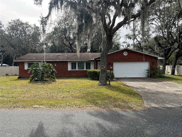 ranch-style home featuring an attached garage, driveway, brick siding, and a front yard