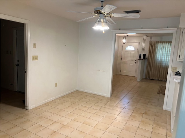 spare room with light tile patterned flooring, ceiling fan, visible vents, and baseboards