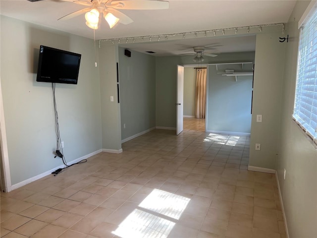 empty room featuring ceiling fan and baseboards