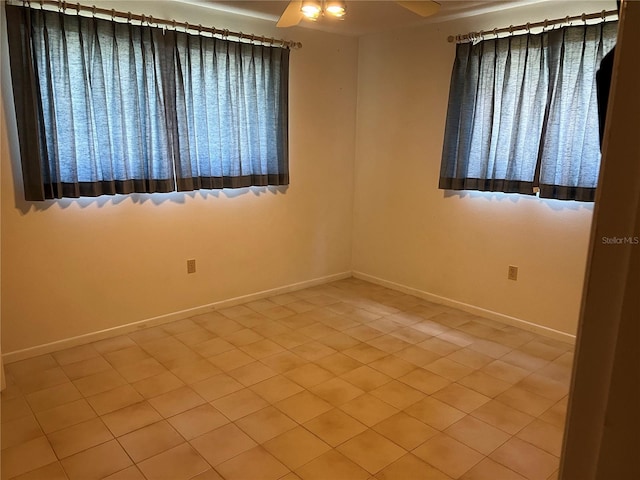 empty room featuring ceiling fan and baseboards