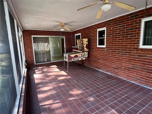 unfurnished sunroom featuring a ceiling fan