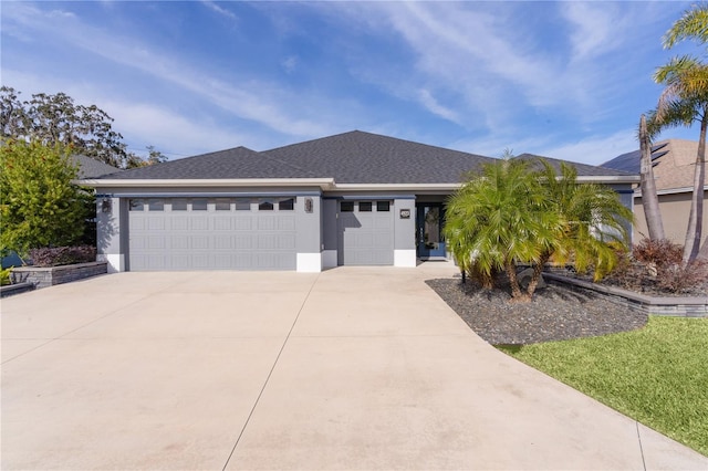 view of front facade featuring an attached garage, roof with shingles, concrete driveway, and stucco siding