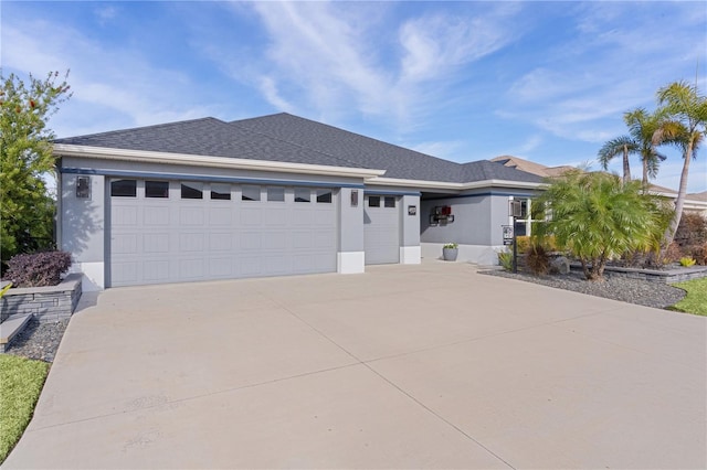 ranch-style home featuring concrete driveway, a shingled roof, an attached garage, and stucco siding