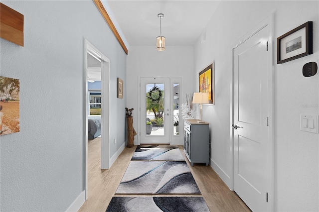 foyer featuring ornamental molding and light hardwood / wood-style floors