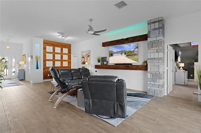 living room featuring ornate columns, ceiling fan, and light wood-type flooring