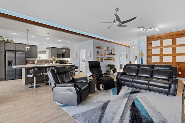 living room featuring ceiling fan and light hardwood / wood-style flooring