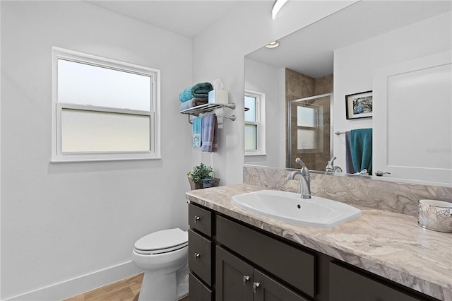 bathroom featuring vanity, plenty of natural light, a shower with door, and toilet