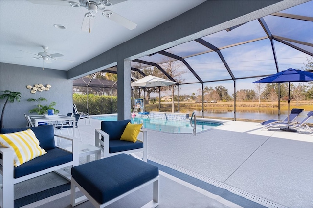 view of patio with a water view, a lanai, a ceiling fan, and an outdoor pool