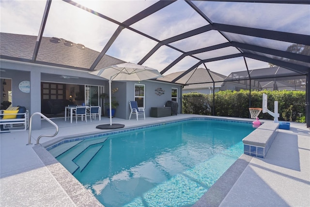 view of swimming pool featuring a patio and glass enclosure