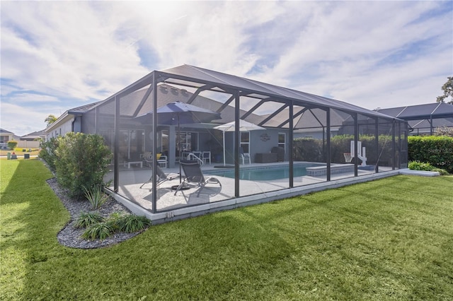 rear view of house featuring a lawn, glass enclosure, and a patio area