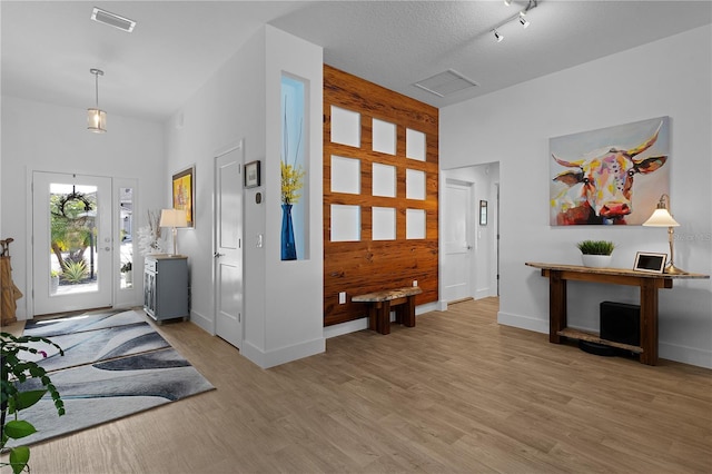 foyer entrance featuring light hardwood / wood-style floors and a textured ceiling