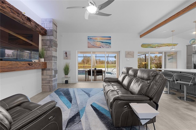 living area featuring light wood-style floors, vaulted ceiling with beams, baseboards, and a ceiling fan