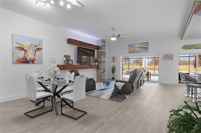 dining room featuring baseboards, visible vents, a ceiling fan, and light wood-style floors