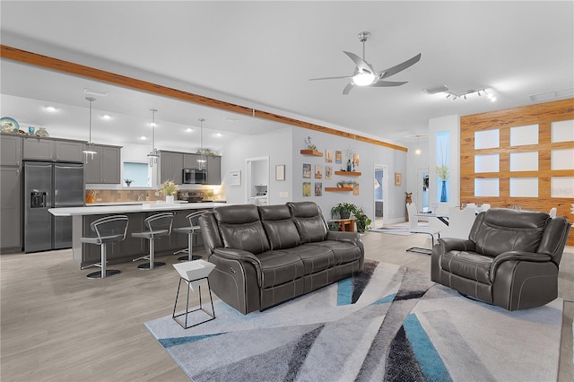 living area featuring a ceiling fan, light wood-type flooring, and visible vents