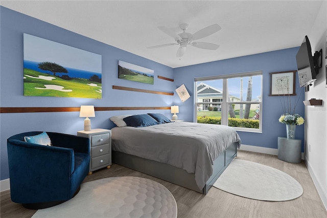 bedroom featuring a ceiling fan, baseboards, and wood finished floors