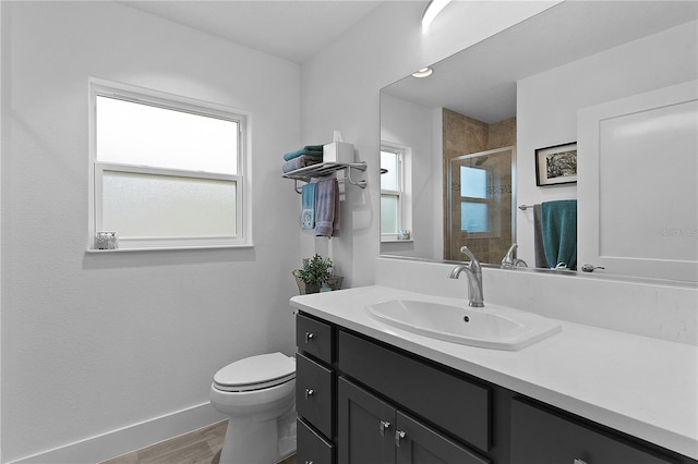 full bath with baseboards, toilet, wood finished floors, vanity, and a shower stall