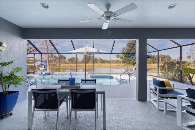 view of patio / terrace with glass enclosure, a ceiling fan, and an outdoor pool