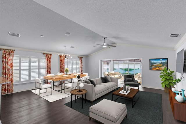 living room with a textured ceiling, ornamental molding, dark hardwood / wood-style flooring, ceiling fan with notable chandelier, and lofted ceiling