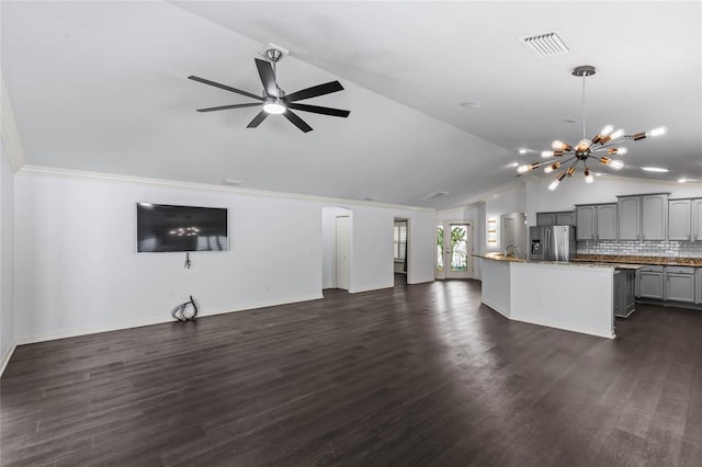 unfurnished living room featuring ceiling fan with notable chandelier, dark hardwood / wood-style floors, and lofted ceiling