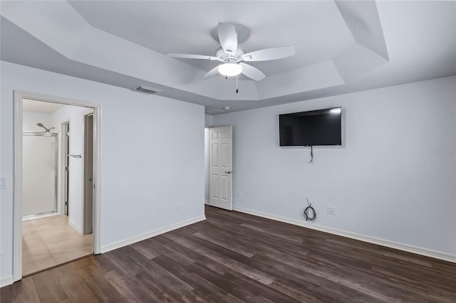 interior space featuring ceiling fan, dark hardwood / wood-style flooring, and a raised ceiling