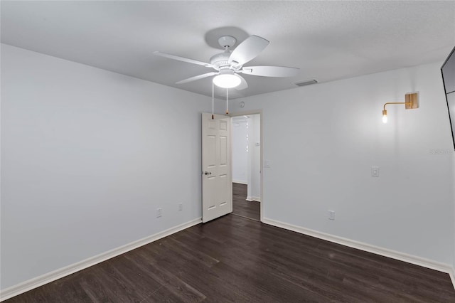 spare room with dark hardwood / wood-style floors and ceiling fan