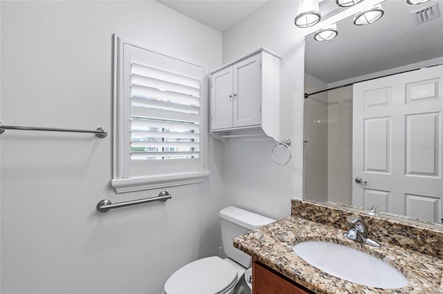 bathroom featuring a shower, toilet, and vanity