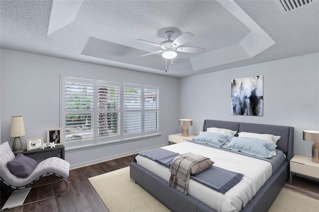 583 Arruda Ter, The Villages, FL 32162 - bedroom featuring a raised ceiling, wood finished floors, a textured ceiling, and a ceiling fan