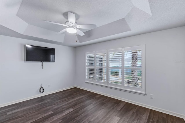 583 Arruda Ter, The Villages, FL 32162 - spare room featuring a tray ceiling, dark wood-style floors, a textured ceiling, ceiling fan, and baseboards