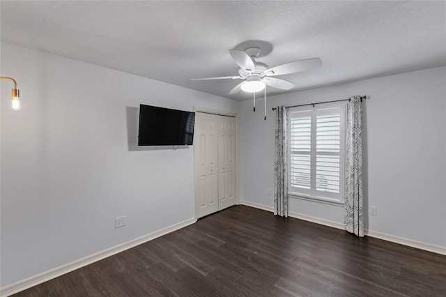 583 Arruda Ter, The Villages, FL 32162 - unfurnished bedroom with dark wood finished floors, baseboards, a closet, and ceiling fan