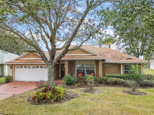 single story home featuring a garage and a front lawn