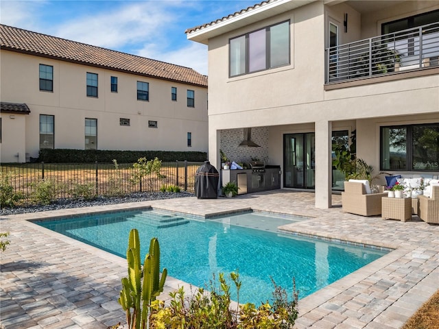 view of pool with area for grilling, outdoor lounge area, exterior kitchen, and a patio